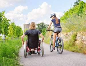 Man in wheelchair with Woman on bicycle.