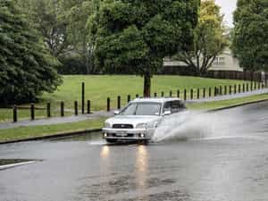 Subaru driving through flooded road.