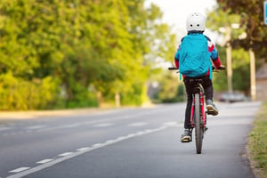 Child biking on a road