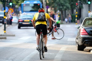 Man cycling in cycleway on busy road